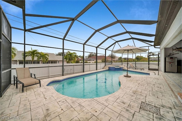 view of swimming pool featuring glass enclosure, an in ground hot tub, and a patio