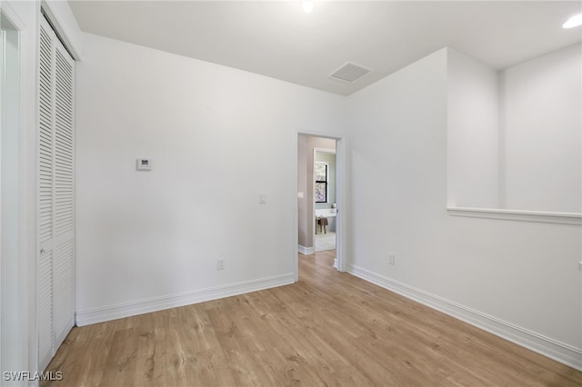 unfurnished bedroom with light wood-type flooring and a closet