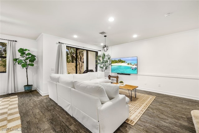 living room with dark wood-type flooring and crown molding