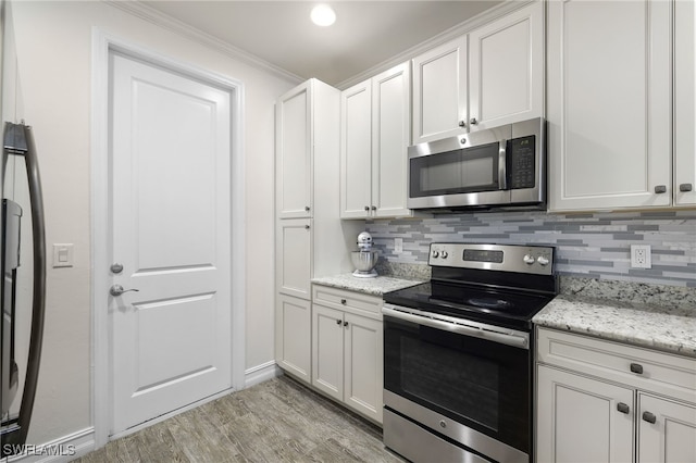 kitchen with white cabinets, backsplash, and stainless steel appliances