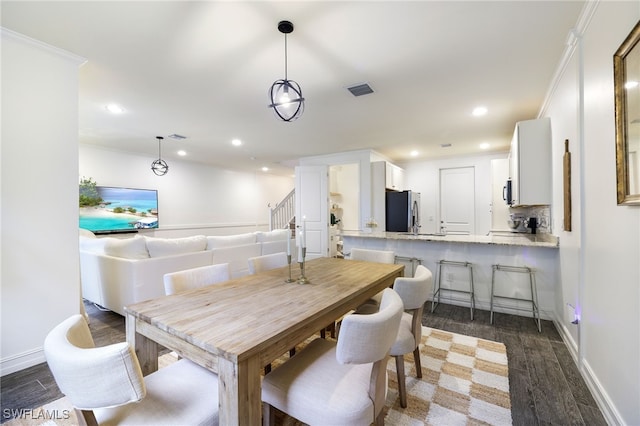 dining area with dark hardwood / wood-style flooring and ornamental molding