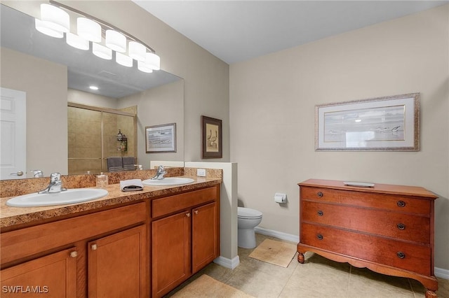 bathroom featuring a shower with shower door, toilet, vanity, and tile patterned flooring