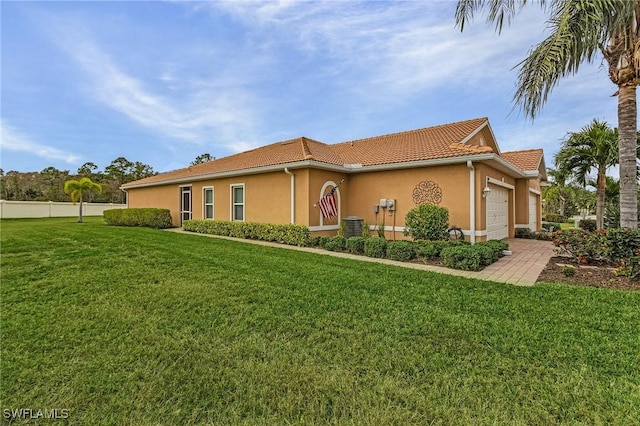 view of front facade featuring a tiled roof, an attached garage, fence, a front yard, and stucco siding