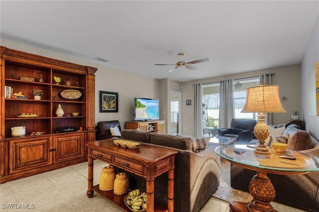 living area with light tile patterned flooring, visible vents, and a ceiling fan