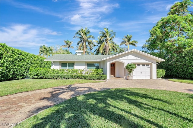 single story home featuring a garage and a front lawn