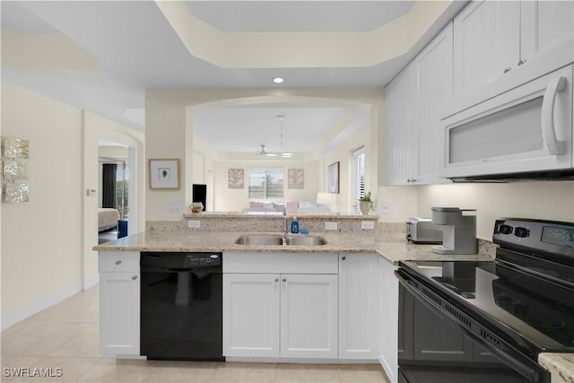 kitchen featuring sink, white cabinets, a tray ceiling, and black appliances