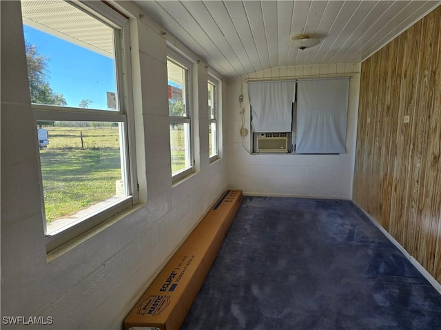 unfurnished sunroom featuring lofted ceiling, wood ceiling, cooling unit, and plenty of natural light