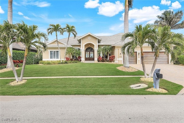 view of front of home with a garage, a front yard, and french doors