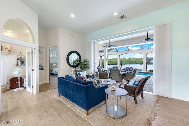 living room with a water view and light wood-type flooring