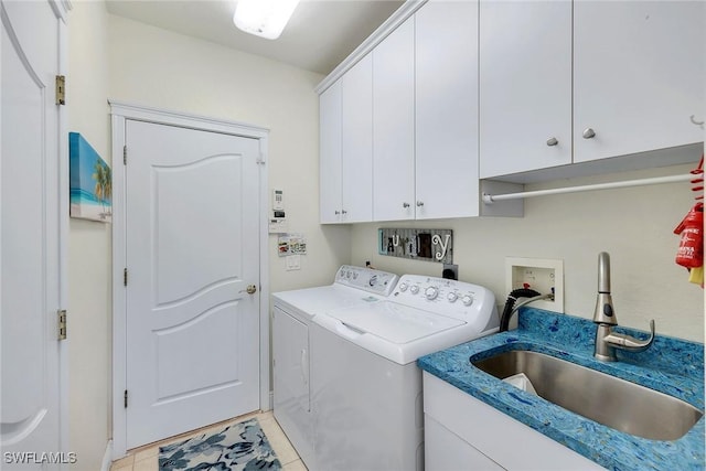 washroom featuring cabinets, sink, light tile patterned floors, and washing machine and dryer