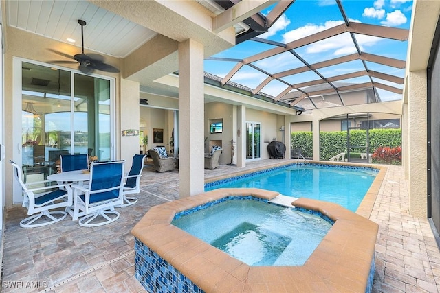 view of swimming pool featuring an in ground hot tub, glass enclosure, ceiling fan, and a patio