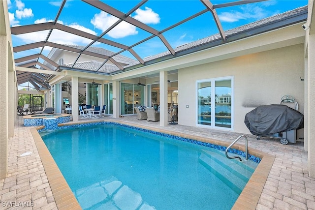 view of swimming pool with a lanai, ceiling fan, a patio, and an in ground hot tub