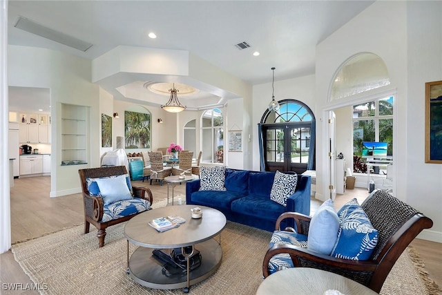 living area featuring visible vents, baseboards, recessed lighting, light wood-style flooring, and french doors