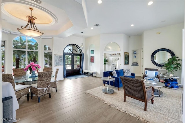 interior space with wood finished floors, visible vents, recessed lighting, french doors, and a raised ceiling