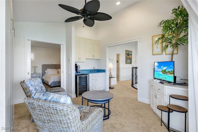 living area featuring wine cooler, baseboards, indoor wet bar, and a ceiling fan