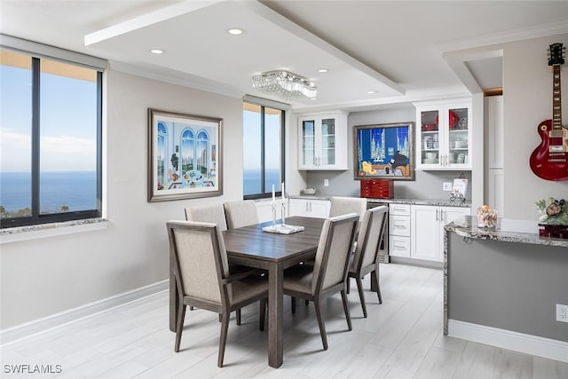 dining room featuring a water view, light hardwood / wood-style flooring, and a wealth of natural light