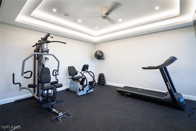 workout area with a tray ceiling