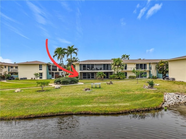 rear view of house featuring a water view and a yard