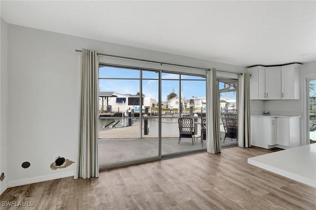 interior space featuring light hardwood / wood-style floors, a water view, and plenty of natural light