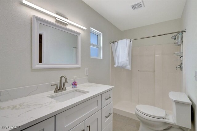 bathroom with vanity, toilet, curtained shower, and tile patterned floors