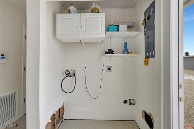 laundry area with washer hookup, hookup for an electric dryer, light tile patterned floors, and cabinets