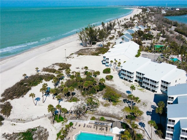 birds eye view of property with a water view and a beach view