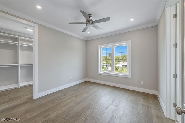 unfurnished bedroom with ceiling fan, a closet, ornamental molding, and light wood-type flooring