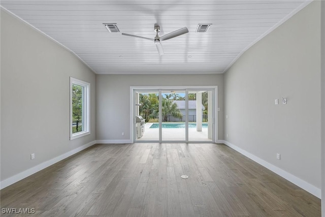 unfurnished room featuring ceiling fan, wood-type flooring, lofted ceiling, and a healthy amount of sunlight