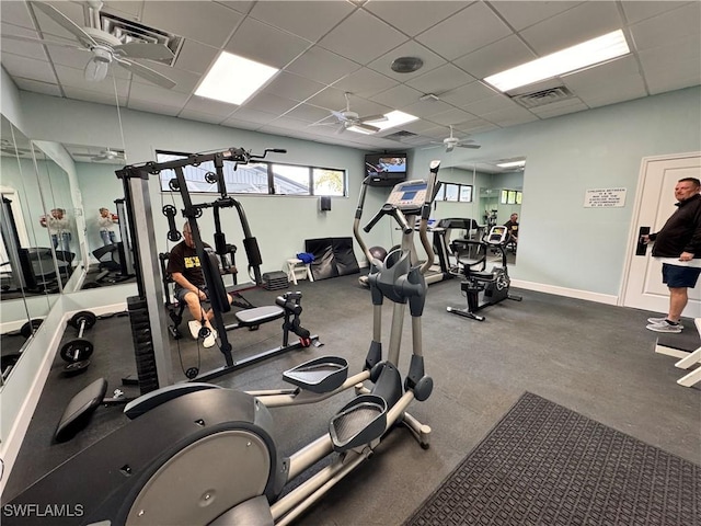 gym with ceiling fan and a paneled ceiling