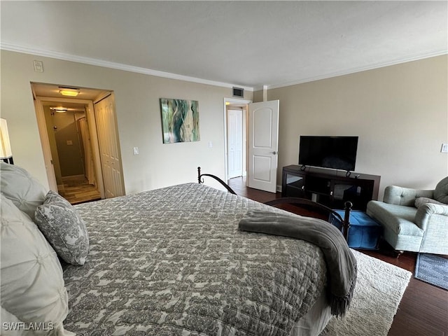 bedroom with crown molding and dark wood-type flooring