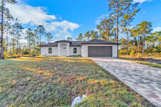 view of front of house featuring a garage and a front lawn