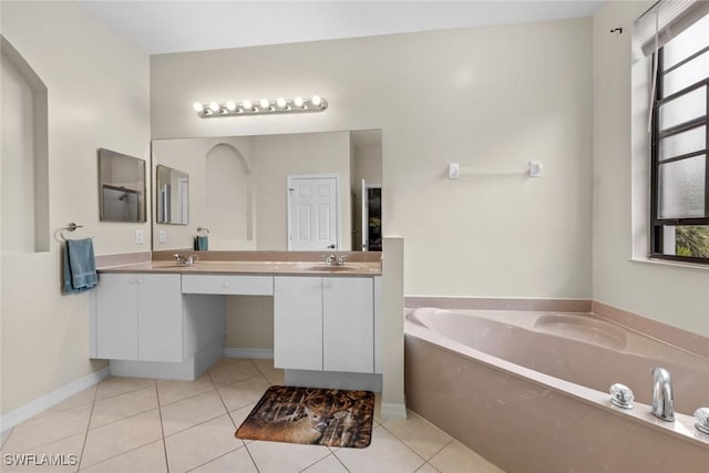 bathroom featuring tile patterned flooring, a bath, and vanity