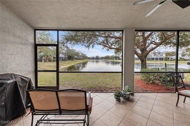 unfurnished sunroom featuring ceiling fan, a healthy amount of sunlight, and a water view