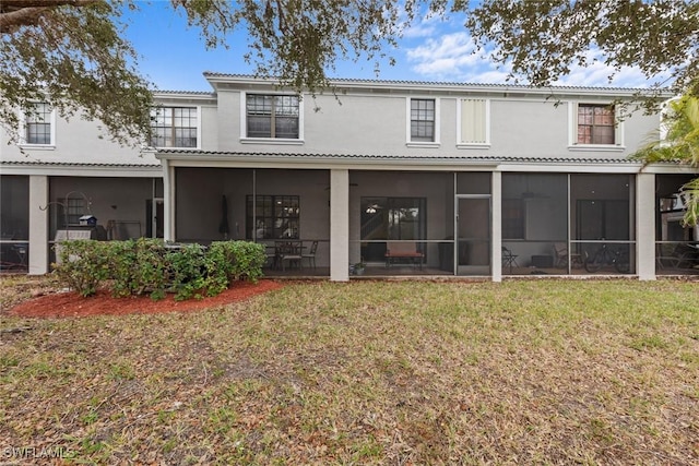 back of house with a yard and a sunroom