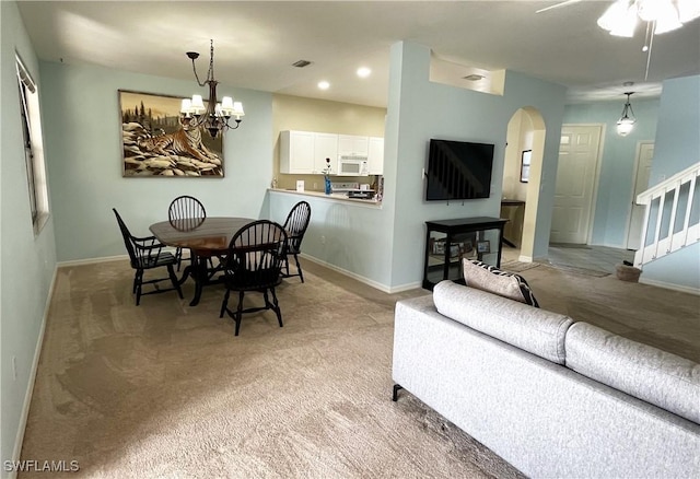 dining room with light carpet and a chandelier