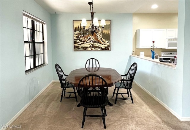 carpeted dining room with a chandelier