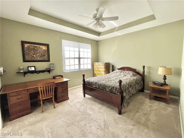 carpeted bedroom featuring a raised ceiling and ceiling fan