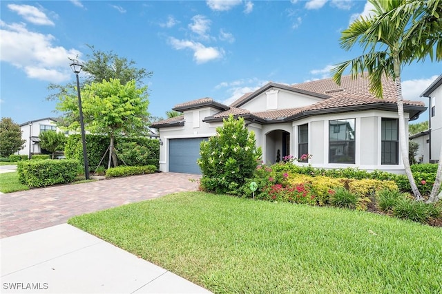 mediterranean / spanish house with a front lawn and a garage