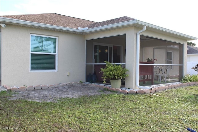 view of property exterior with a sunroom and a yard