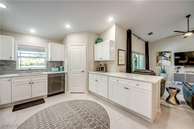 kitchen featuring ceiling fan, dishwasher, sink, light tile patterned flooring, and white cabinetry