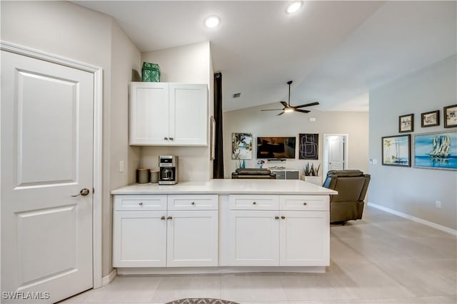 kitchen featuring ceiling fan, light tile patterned floors, lofted ceiling, and white cabinets