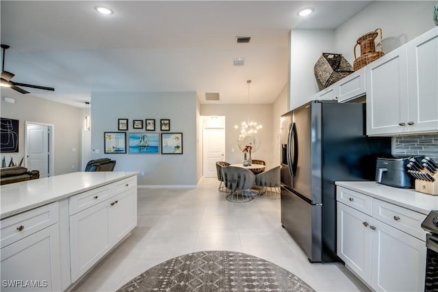 kitchen with white cabinetry, refrigerator with ice dispenser, tasteful backsplash, decorative light fixtures, and ceiling fan with notable chandelier