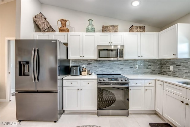 kitchen with appliances with stainless steel finishes, white cabinetry, and tasteful backsplash