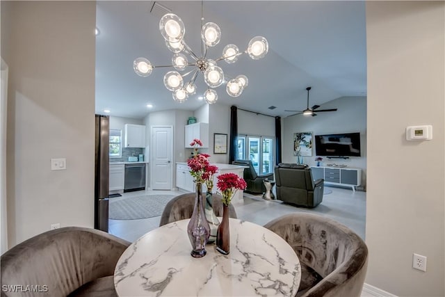 dining space with lofted ceiling and ceiling fan with notable chandelier