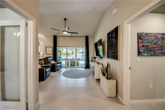 hallway with lofted ceiling and light tile patterned floors