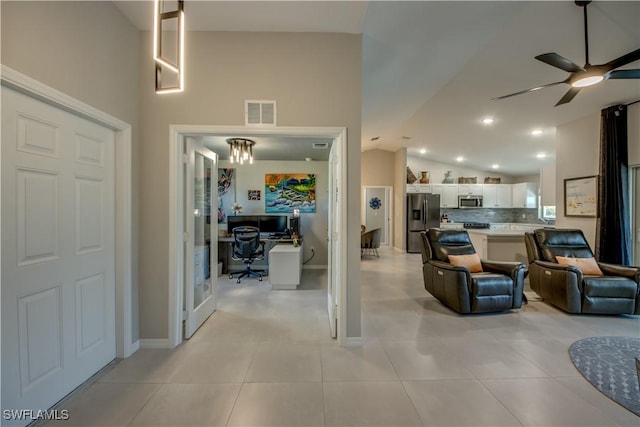 living room with ceiling fan, light tile patterned floors, and vaulted ceiling