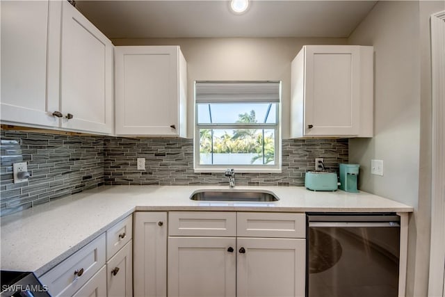 kitchen with white cabinets, backsplash, dishwasher, and sink