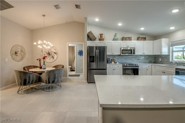 kitchen with stainless steel appliances, backsplash, vaulted ceiling, pendant lighting, and white cabinets