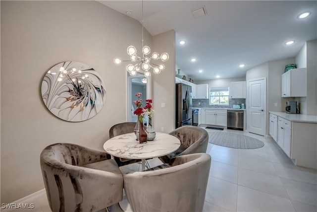 tiled dining space with an inviting chandelier and lofted ceiling