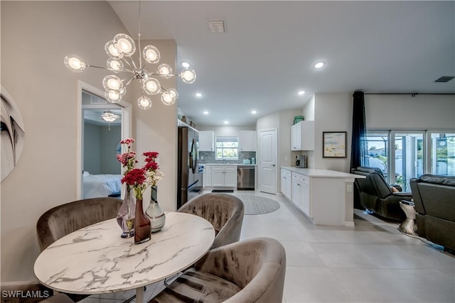 dining space with lofted ceiling and an inviting chandelier